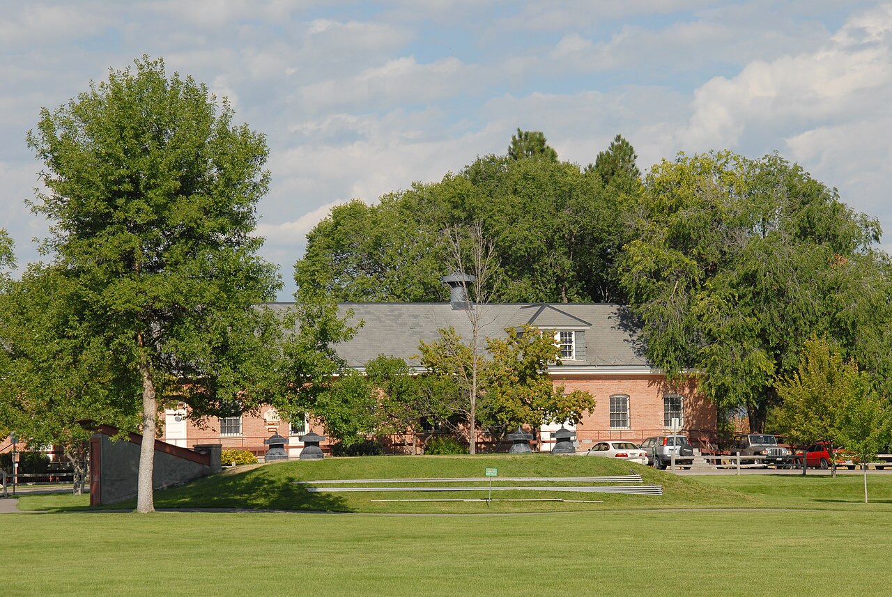 The red-brick Quartermaster's Storehouse at Fort Missoula, seen across a lawn and shade trees
