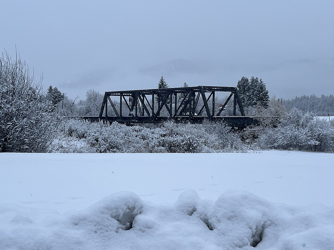 A steel truss railroad bridge over the Blackfoot River near Milltown after a heavy snowfall